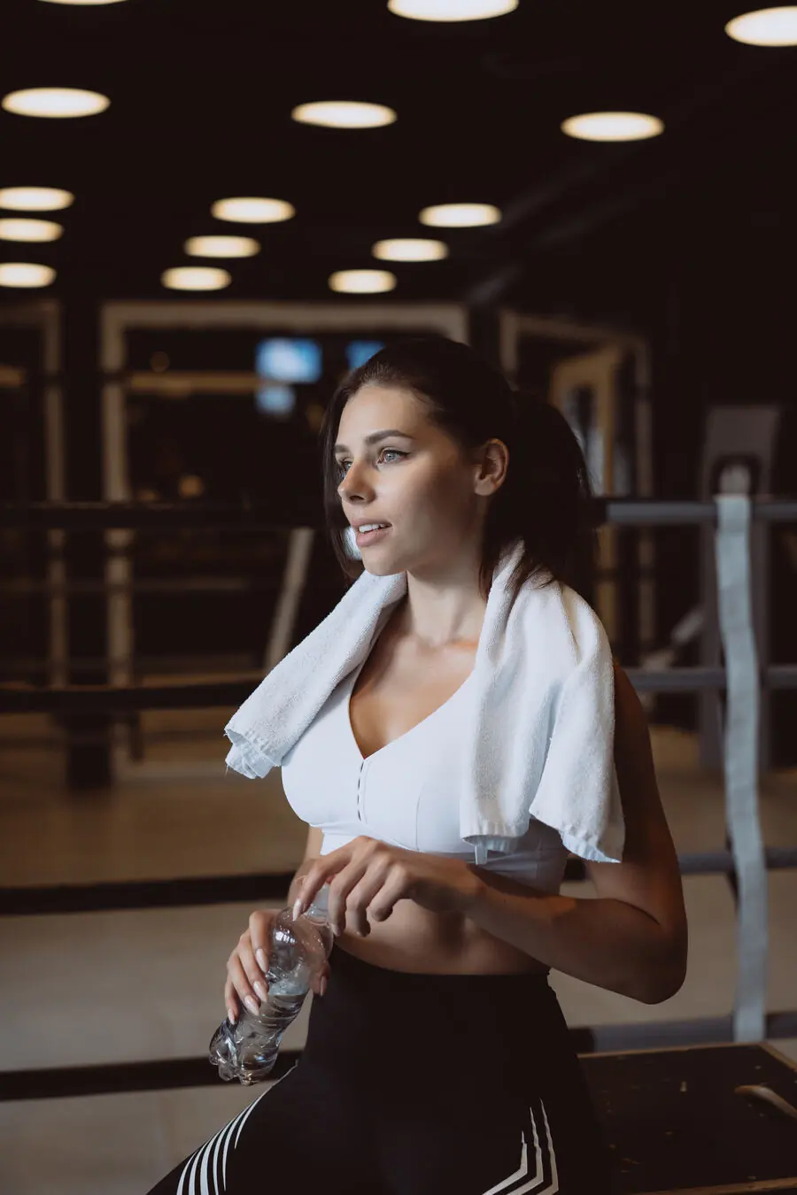 Mulher com toalha nos ombros na academia